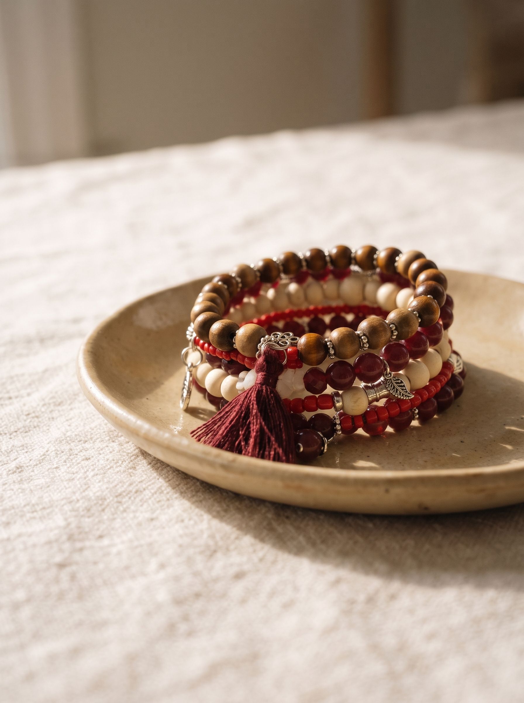 Pulsera de madera y cuentas rojas sobre un plato de cerámica