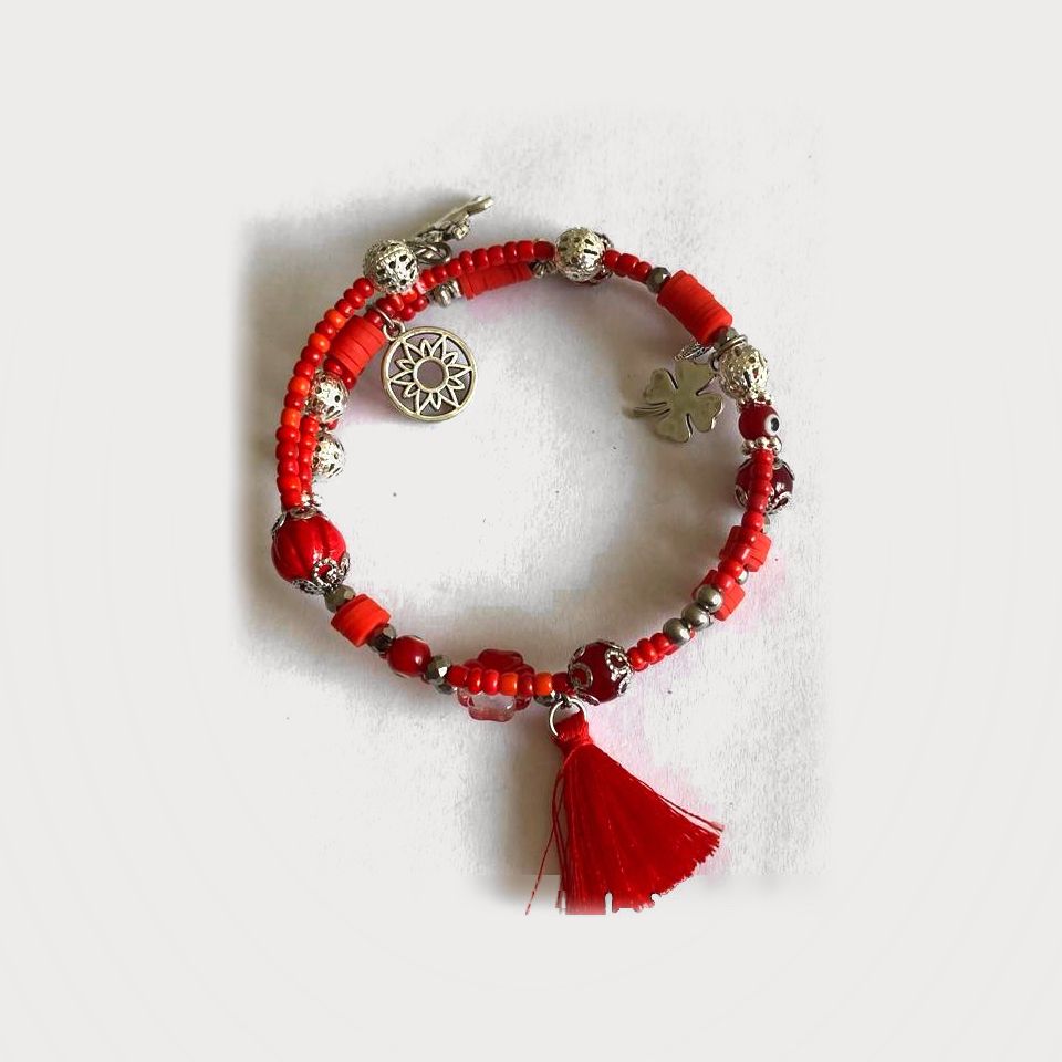 Pulsera Cauce de cuentas de vidrio rojas con dijes de pewter y borla roja